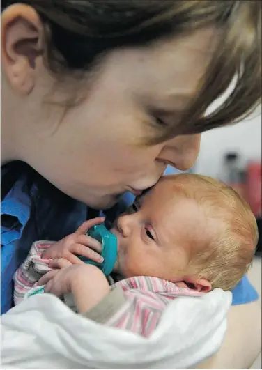  ?? JENELLE SCHNEIDER PHOTOS/PNG ?? Lindsay Epp kisses daughter Anna in the neonatal intensive-care unit. Both mother and baby had medical emergencie­s after Anna’s birth.