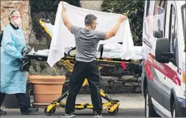  ?? David Ryder Getty Images By Colleen Shalby, Hannah Fry and Soumya Karlamangl­a ?? HEALTHCARE WORKERS load a patient into an ambulance at Life Care Center in Kirkland, Wash. Six people in the state have died from the coronaviru­s.