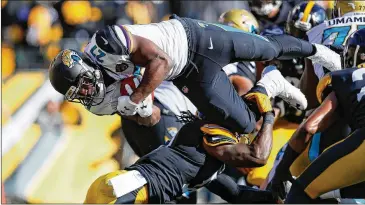  ?? KEVIN C. COX / GETTY IMAGES ?? Jaguars running back Leonard Fournette dives into the end zone in the first quarter for the first of his three TDs in Sunday’s victory. He ran for 109 yards on 25 carries and caught two passes for 10 yards.