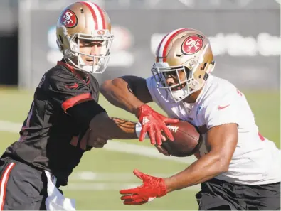  ?? Tony Avelar / Special to The Chronicle ?? Jimmy Garoppolo (left) hands off to running back Jeremy McNichols during practice in Santa Clara. On Sunday, Garoppolo will be starting in Chicago.