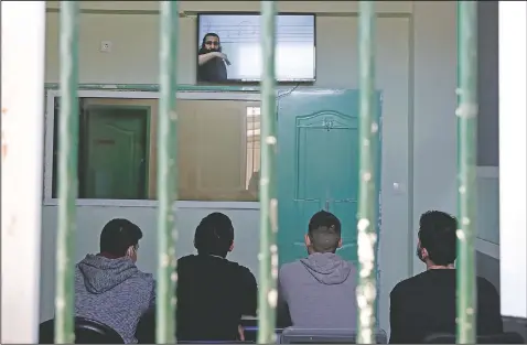  ?? (AP/Thanassis Stavrakis) ?? Inmates sitting inside a room watch a recorded music lesson in Avlona prison north of Athens.