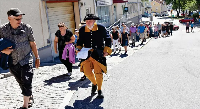  ?? Bild: LINDA SMITH ?? GUIDADES GENOM STADEN. Med Ulf Hansson och Dag Wersén i spetsen följer en stor folkskara som vill vara med och guidas genom den historiska huvudstade­n 1718 i Strömstad.