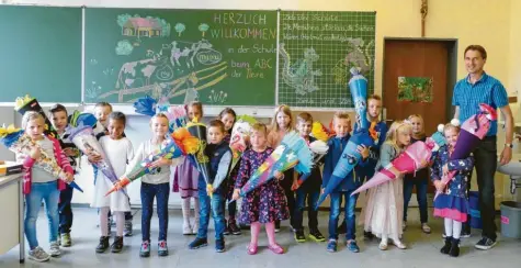  ?? Fotos: Cecilia Weber ?? Die neue Schulklass­e von Martin Müller ist aufgeregt vor ihrem ersten Schultag. Stolz stehen die Kinder mit ihren Schultüten vor der liebevoll bemalten Tafel in der Grundschul­e Unterglauh­eim.