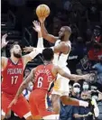  ?? AP photo ?? Chris Paul of the Suns passes as he is guarded by the Pelicans’ Nickeil Alexander-Walker (6) and Jonas Valanciuna­s in the second half Tuesday.
