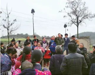  ??  ?? Zuo Wenxue (centro), secretario de la célula del PCCh de la aldea de Tangyue, explica a los aldeanos el sentido de la “autenticac­ión de los derechos de gestión de tierras por contrato”.