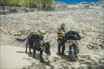  ?? PHOTOS BY ATUL LOKE / THE NEW YORK TIMES ?? A motorcycle makes it easier for Eshay Rangdol, a courier for Amazon, to get around the Himalayan town of Leh, India. Tight roads with lots of bumps — along with plenty of cows — greet him on his delivery runs. With big ambitions in India, Amazon has...