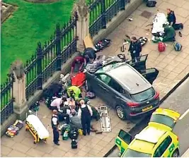  ?? AP ?? Police officers gather around a car adjacent to the Houses of Parliament in London after the House of Commons sitting was suspended after gunfire outside. —