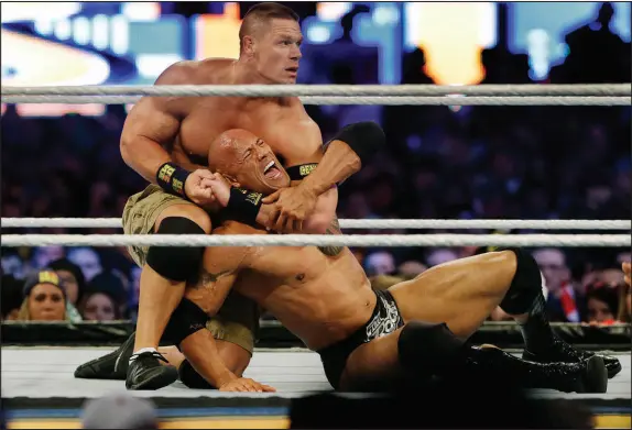  ?? MEL EVANS / ASSOCIATED PRESS FILE (2013) ?? John Cena, top, wrestles Dwayne “The Rock” Johnson on April 7, 2013, at Wrestleman­ia in East Rutherford, N.J. Johnson is back to perform in one of the main events this weekend’s Wrestleman­ia.