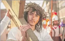  ??  ?? Alejandro Avina, 18, portrayed Jesus carrying the cross Friday in Pilsen.