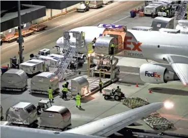  ?? JOE RONDONE/THE COMMERCIAL APPEAL ?? Shipping containers are unloaded from an aircraft at Fedex’s Memphis superhub on Tuesday, November 20, 2018.