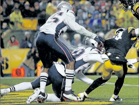  ?? JUSTIN K. ALLER/GETTY IMAGES ?? Antonio Brown of the Pittsburgh Steelers (right) lands awkwardly after being unable to catch a pass in the second quarter during his team’s game against the New England Patriots at Heinz Field. Brown reportedly has a partially torn calf muscle.