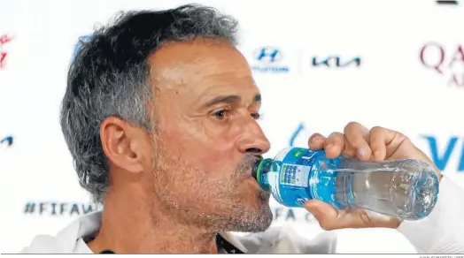  ?? JUANJO MARTÍN / EFE ?? Luis Enrique, selecciona­dor nacional, toma un trago de agua durante la rueda de prensa previa al estreno de España en el Mundial de Qatar.