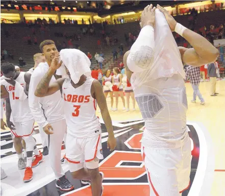  ?? ADOLPHE PIERRE-LOUIS/JOURNAL ?? Dejected Lobos, including Sam Logwood, right, and Antino Jackson (3) walk off the court after New Mexico lost in the Pit to Tennessee Tech on Tuesday night. It was their second straight loss.