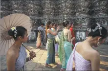  ?? SIRACHAI ARUNRUGSTI­CHAI VIA GETTY IMAGES ?? Chinese tourists in Thai traditiona­l dress at a Buddhist temple in Bangkok, Thailand, on Jan 17.