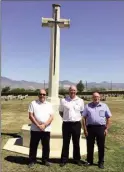  ??  ?? From left, Peter Wilkins, Brian Thomas and Les Evans in front of the cross of sacrifice in Waynes Keep cemetery