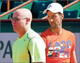  ?? Christophe Ena / The Associated Press ?? Defending champion Novak Djokovic (right) watches his new coach Andre Agassi during a training session for the French Open at the Roland Garros stadium Friday in Paris.