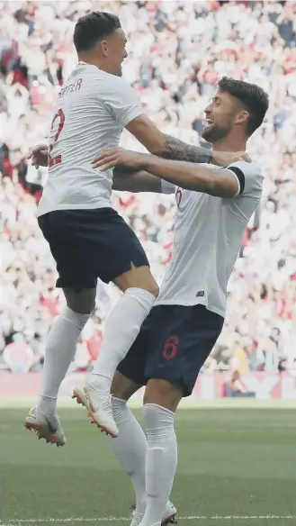  ??  ?? Kieran Trippier jumps on goalscorer Gary Cahill to celebrate England’s opener at Wembley on Saturday.