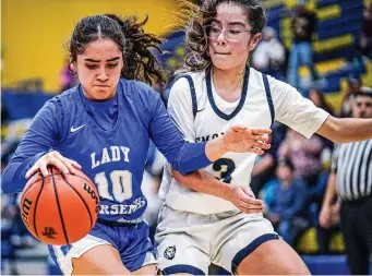  ?? PHOTOS BY GABRIELA CAMPOS/NEW MEXICAN FILE PHOTO ?? St. Michael’s Mariella Ruiz, left, tries to maintain control of the ball while being guarded by Santa Fe High’s Desi Martinez during a game earlier this season. The Lady Horsemen are the No. 7 seed in Class 3A.