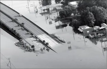  ?? ASSOCIATED PRESS ?? PEOPLE LAUNCH BOATS FROM AN OVERPASS INTO FLOODWATER­S on Thursday. in the aftermath of Tropical Storm Harvey in Kountze, Texas,