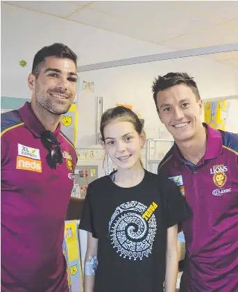  ?? @seanteuma Picture: Sean Teuma ?? STARSTRUCK: Aalani Mears meets Brisbane Lions players Marcus Adams (left) and Hugh McCluggage during a visit to Toowoomba Hospital yesterday.
SEAN TEUMA