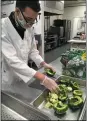  ??  ?? Harold Starks of Elyria, a Spectrum Vocational intern student, prepares green peppers for Spectrum Catering dinners.