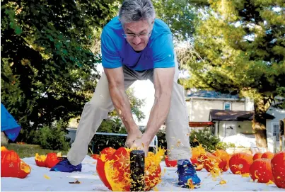  ?? (Brendan McDermid/Reuters) ?? ASHRITA FURMAN, the record holder for the most Guinness world records, smashes a pumpkin during an attempt to break the record for the most pumpkins smashed in one minute last month in the Queens borough of New York City.