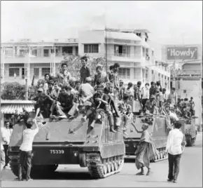  ?? SJOBERG/AFP ?? Young Khmer Rouge guerrilla soldiers atop their US-made armoured vehicles enter Phnom Penh on April 17, 1975, the day Cambodia fell under the control of the communist Khmer Rouge forces.