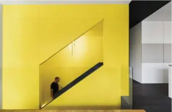  ?? ADRIEN WILLIAMS PHOTOS ?? The yellow staircase acts as the central focal point of the home, which cost $900,000 to renovate.