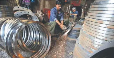  ?? Reuters ?? ↑ A man works inside a workshop in an industrial area in Mumbai, India.