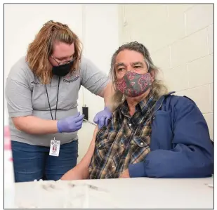  ?? (Arkansas Democrat-Gazette/Staci Vandagriff) ?? Amanda White, an EMS specialist with the Arkansas Department of Health, gives Michael Kerr a shot of the Johnson & Johnson coronaviru­s vaccine Thursday at the Little Rock Compassion Center.