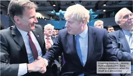  ??  ?? Crowning moment... Jeremy Hunt congratula­tes Boris Johnson yesterday when result was announced the