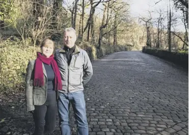  ??  ?? HERITAGE DESTROYED: Residents, including Catherine Gill and husband Andrew Gill, have condemned the removal of old cobble stones in Woodhouse Lane, Copley, as part of a road repair resurfacin­g scheme.