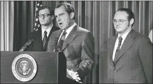  ?? (File Photo/AP/Harvey Georges) ?? President Richard Nixon explains aspects of the special message in June 1971 sent to the Congress, asking for an extra $155 million for a new program to combat the use of drugs. He labeled drug abuse “a national emergency” and said the money would be used to “tighten the noose around the necks of drug peddlers and thereby loosen the noose around the necks of drug users.” At left is Egil Krogh, deputy director of the Domestic Council. At right is Dr. Jerome Jaffe, who was recruited by Nixon to lead a new drug strategy.