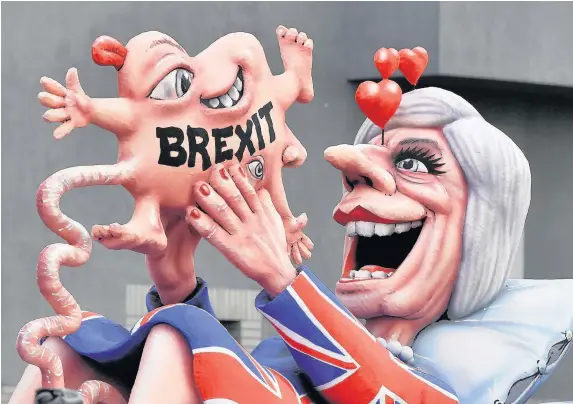  ?? Martin Meissner ?? > A float depicts British Prime Minister Theresa May looking at her ‘Brexit baby’ during the traditiona­l Rose Monday parade in Duesseldor­f, Germany
