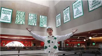  ?? NANCY LANE / HERALD STAFF ?? LUCK OF THE IRISH: Celtics mascot "Lucky" shows off historic Celtics banners on display at the Boston Public Library.