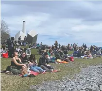  ?? ?? People assemble in Breakwater Park to watch the eclipse in Kingston on Monday. PETER HENDRA