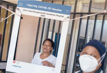  ?? THEMBA HADEBE/AP ?? Maggie Sedidi, left, rejoices after receiving a COVID-19 shot from a staffer March 5 in Soweto, South Africa. She is optimistic: “By next year, or maybe the year after, I really do hope that people will be able to begin returning to normal life.”