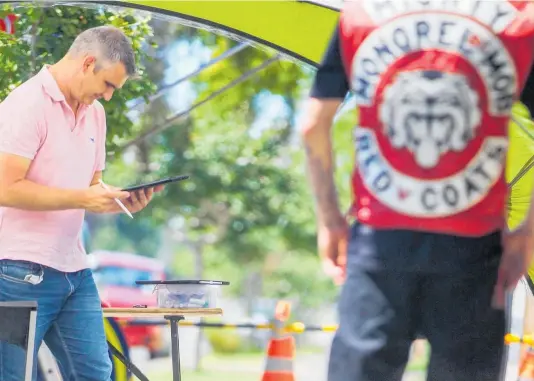  ?? PHOTO / PAUL TAYLOR ?? A member of the Mongrel Mob watches the police site investigat­ion on Friday.