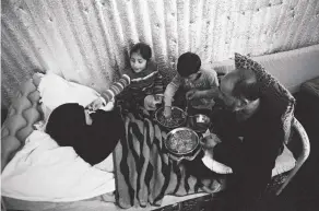  ??  ?? Above: Khouloud, paralysed by a sniper’s bullet in 2013, in the makeshift tent in the Bekaa Valley she calls home, with her husband Jamal and two of their four children