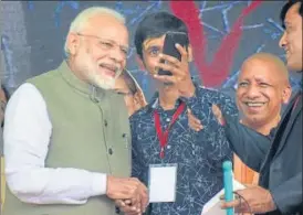  ?? PTI PHOTO ?? ■
A differentl­y abled boy clicks a selfie with Prime Minister Narendra Modi during a programme in Prayagraj on Saturday. Also seen is chief minister Yogi Adityanath.