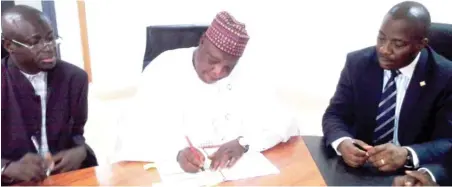  ??  ?? The Director General Niger State Pension Board Alhaji Benu Yahaya Ahmed signing fund management agreement on behalf of Niger State Government, watching with keen interest is MD/ CEO Premium Pension Ltd. Mr. Wilson Ideva ( right) and Mr. Mohammed Ndagi...