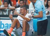  ?? ISSEI KATO / REUTERS ?? Nick Kyrgios grimaces as he receives medical treatment during his first-round win over Gastao Elias on Jan 16. The fiery 21-year-old exited the Australian Open in the second round.