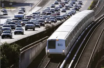  ?? PHOTO: DOUG DURAN — BAY AREA NEWS GROUP ?? A BART train travels next to commuter traffic on eastbound Highway 24in Lafayette, Calif., on Wednesday, March 20, 2019.