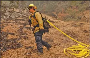  ?? (The New York Times/Daniel Dreifuss) ?? Firefighte­r Skip Irland of Hemet, Calif., moves in on a wildfire hot spot Thursday in California’s Sequoia National Forest. While progress has been made in the recent round of fires, the effort has taxed personnel and resources in a fire season that has barely begun.