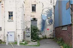  ?? Foto: Getty Images ?? Das Graffiti-Kunstwerk von Banksy mit dem Titel „Girl with a Pierced Eardrum“(Mädchen mit durchstoch­enem Trommelfel­l) mit einer schützende­n Gesichtsma­ske in Bristol.