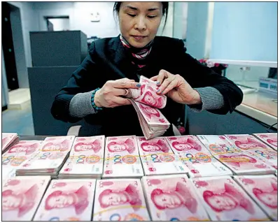  ?? AP ?? A clerk counts Chinese currency notes at a bank in Huaibei, China. The Chinese yuan slid Thursday to its lowest level in almost two years.