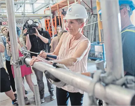  ?? PETER LEE WATERLOO REGION RECORD ?? Premier Kathleen Wynne puts together some scaffoldin­g components during a demonstrat­ion at Carpenters Local 785 in Cambridge Monday.