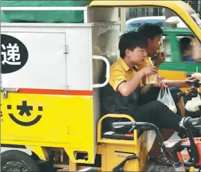  ?? JU HUANZONG / XINHUA ?? Clockwise from top left: An employee of Ofo prepares to move damaged bikes to a designated safe spot. PROVIDED TO CHINA DAILY Two deliveryme­n eat breakfast aboard an express cart. XU JINGXING / CHINA DAILYA designated driver employed by E-Daijia takes a client home during Spring Festival 2017.