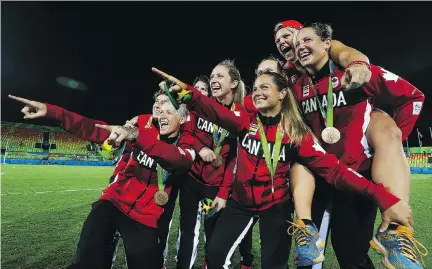  ?? DAVE ABEL ?? Canada’s women’s rugby sevens team celebrates winning the bronze medal after beating Great Britain 33-10 on Monday.