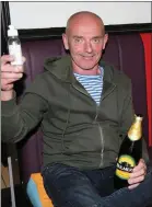  ??  ?? Martin ‘Bam Bam’ O’Neill, with a bottle of Sanitizer in one hand and a bottle of Bulmer’s in the other, at Kelly’s Bar in Kanturk on Monday night.